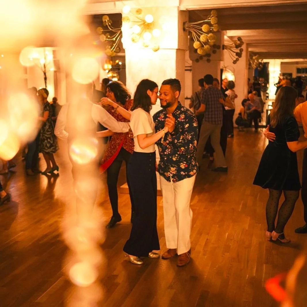 Adults enjoying social partner dancing together on a warm, inviting dance floor